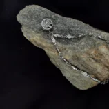 Srebrna bransoletka z zawieszką Drzewo Życia ułożona na kamieniu