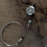 Otwarta bransoletka w srebrnym kolorze z ozdobnym detalem