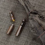 Naszyjnik aromaterapeutyczny w kształcie walca z ażurowym wzorem lasu i wkładem filcowym.