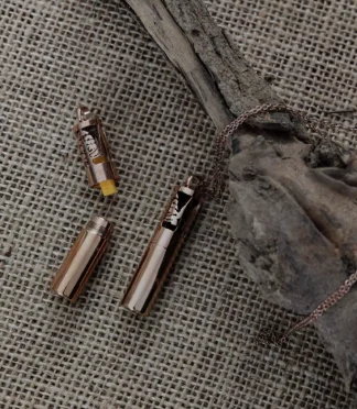 Naszyjnik aromaterapeutyczny w kształcie walca z ażurowym wzorem lasu i wkładem filcowym.