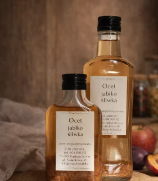 Dwie butelki octu z z jabłek i śliwej na stole