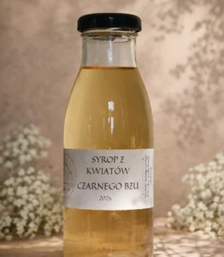 Szklana butelka z syropem z kwiatów czarnego bzu i kwiatami bzu w tle