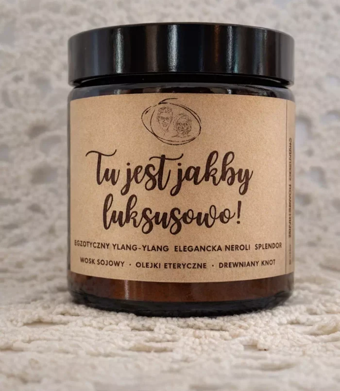 Świeca zapachowa w słoiku z napisem "Tu jest jakby luksusowo" na etykiecie