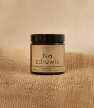 Świeca sojowa w szklanym słoiku z etykietą z napisem "Na zdrowie"